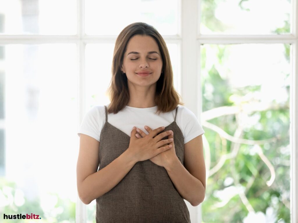 A woman with hands over her heart, feeling gratitude and inner peace.






