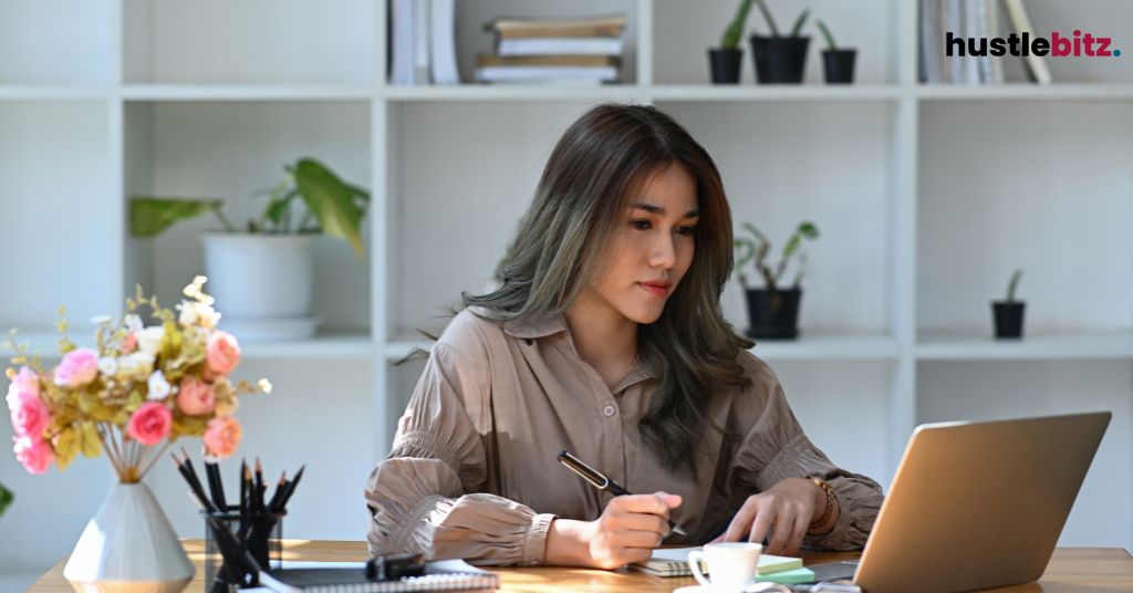 A woman inside the office with laptop and bookshell background