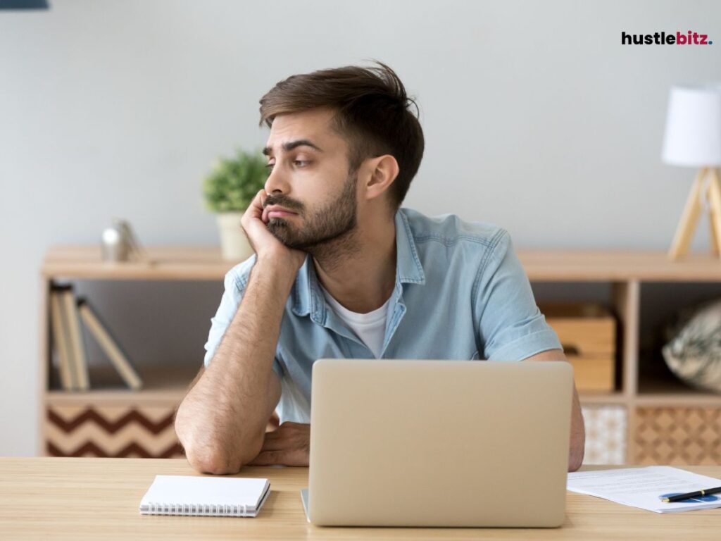 A man looking bored in front of his laptop