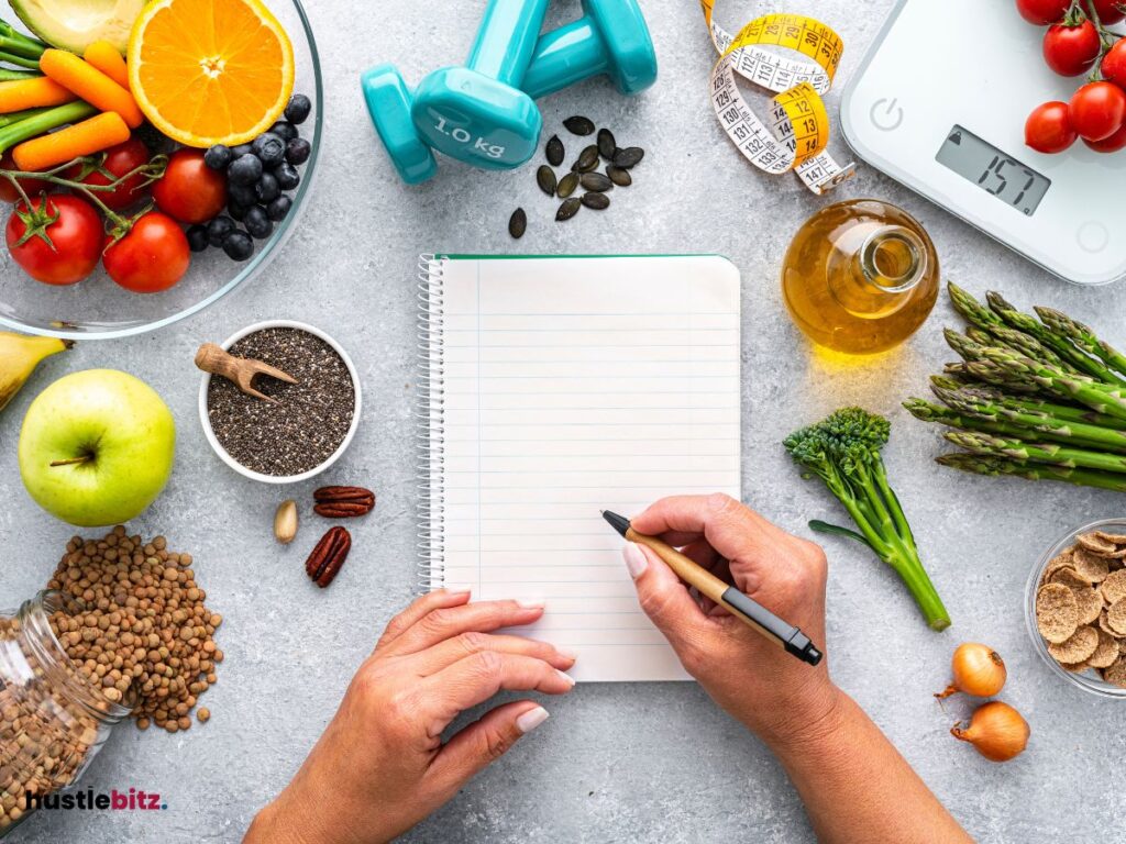 Variety of fruits and vegetables, and a notebook and pen.