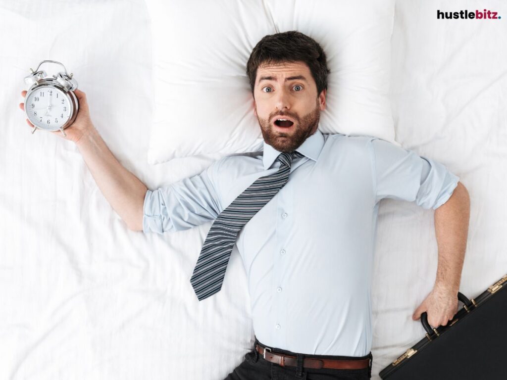 A man in the bed, wearing corporate attire and holding a clock