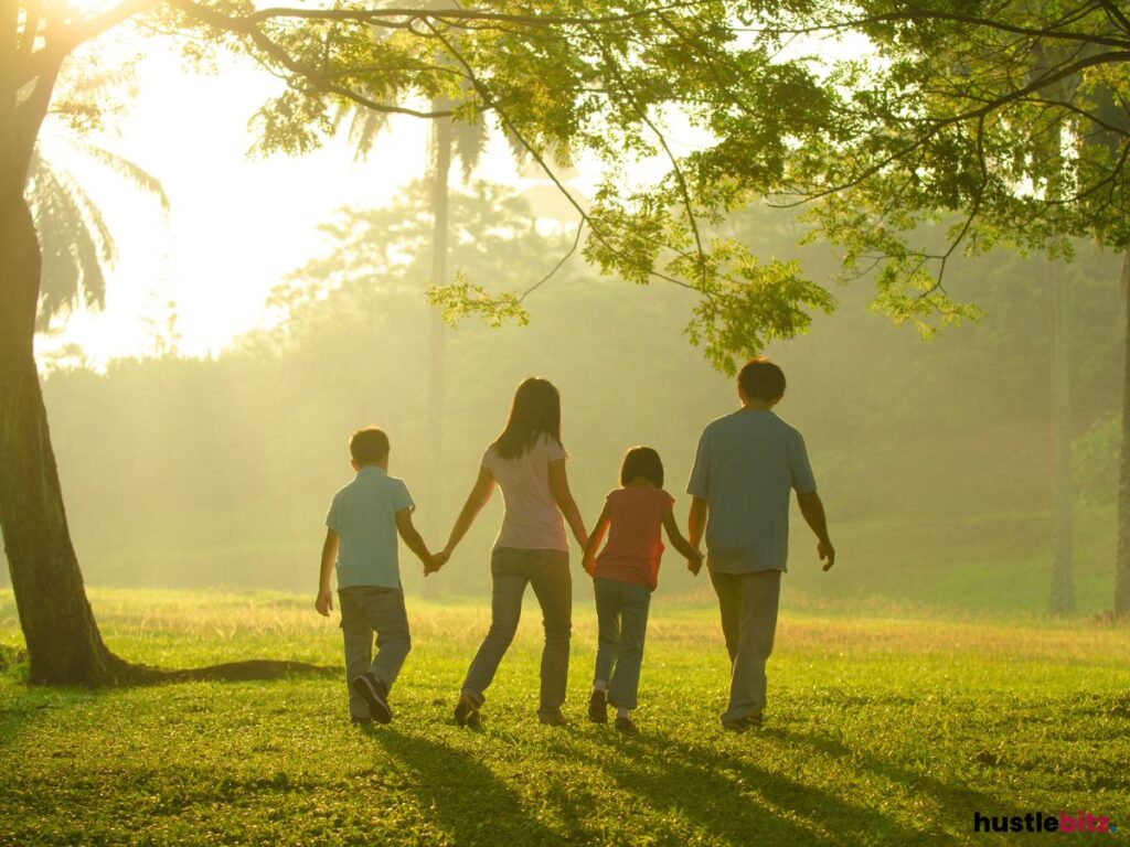 A family holding hands walking in a greenery