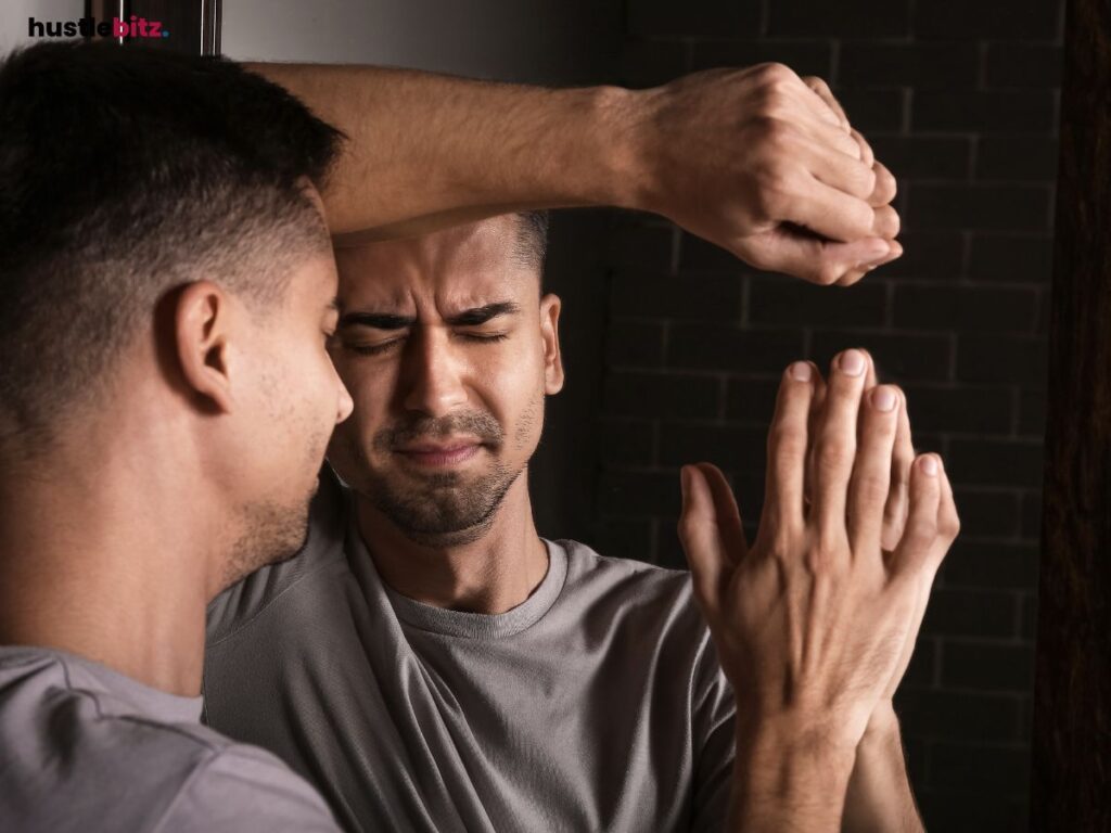 A man at the mirror scrunching his face