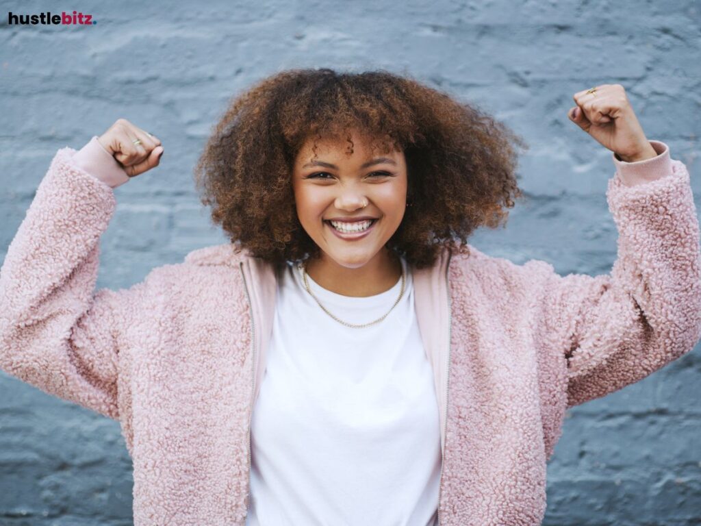 Smiling woman with raised fists.