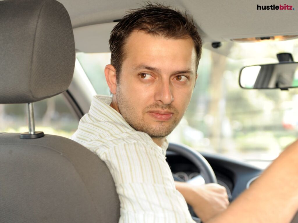 Man driving, looking backward while in a car.