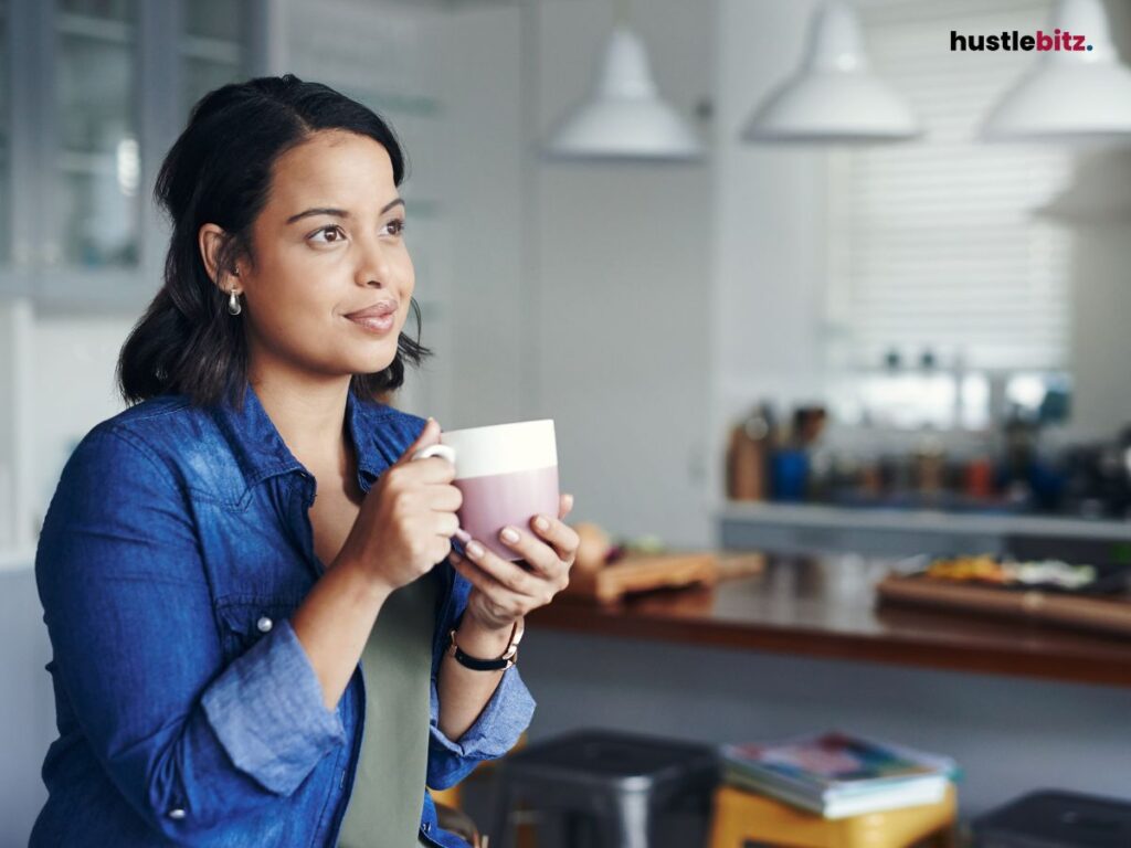 A woman holding a mug while smiling.