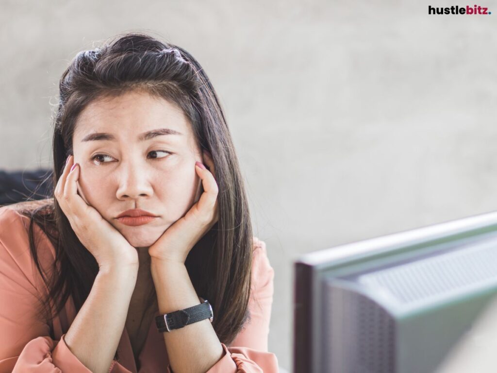 Woman resting her chin on her hands, looking bored.