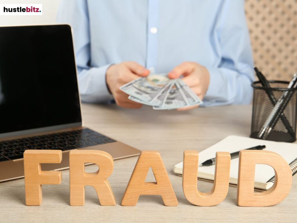 A person holding a money with the words FRAUD in front.