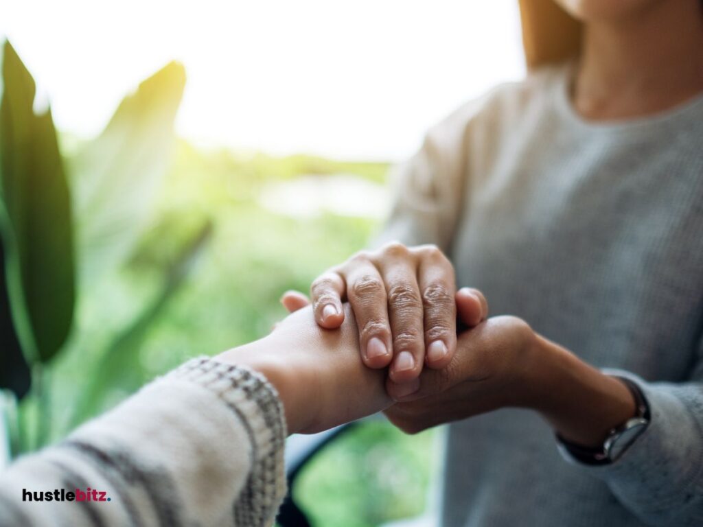 A woman holding the hands of another person.