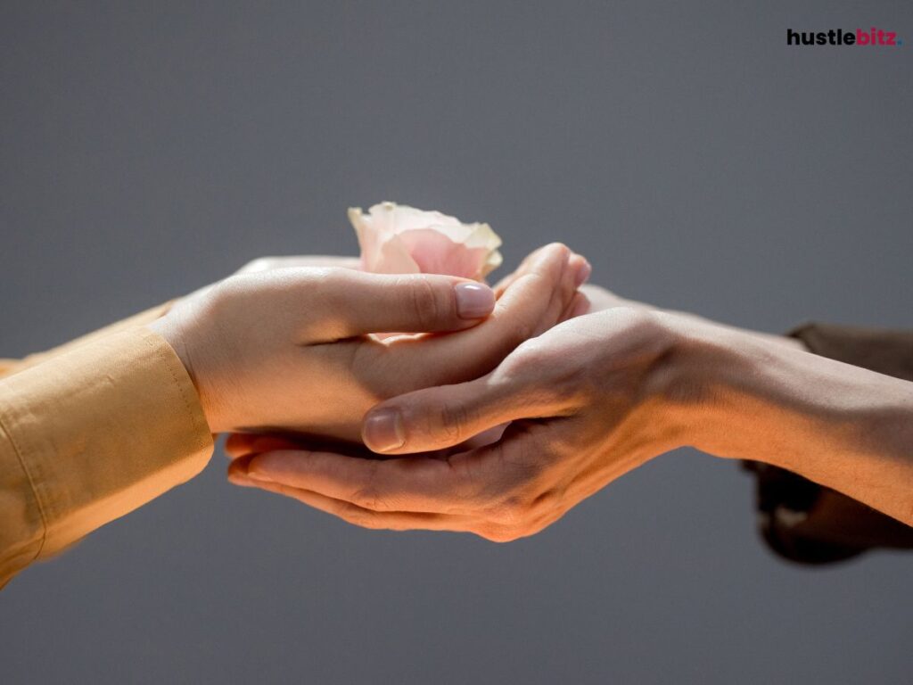 Two hands holding a flower.