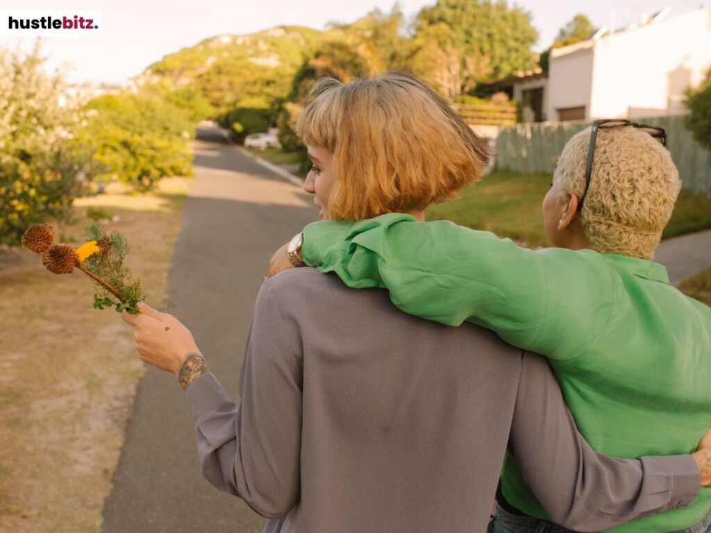 Two woman walking. One woman holding a flower.