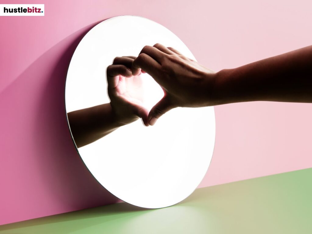A hand forming a heart in the mirror.