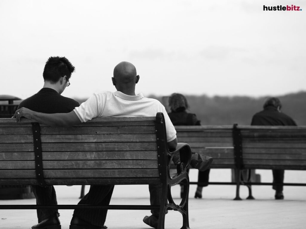 Two man sitting on a bench.