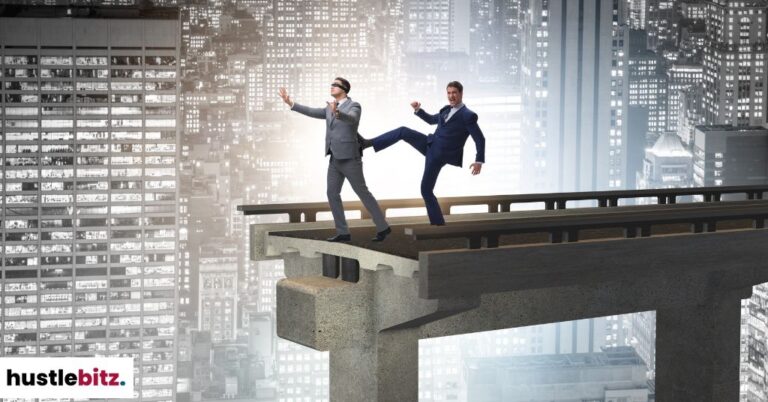 A man kicking a blindfolded man in the end of the bridge.