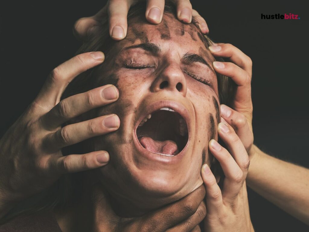 A woman screaming in pain while multiple hands are touching her face.