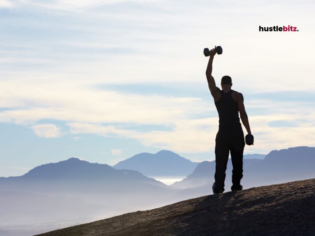 A man lifting a dumbbell on top of the mountain.
