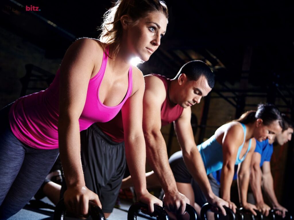 A group of focused people doing kettlebell exercises during a workout class.