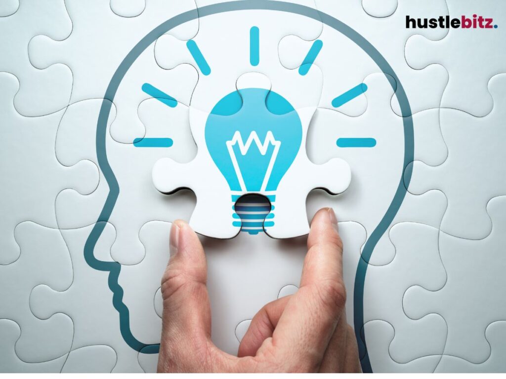 A hand completing a puzzle of a human head drawing with a lightbulb.