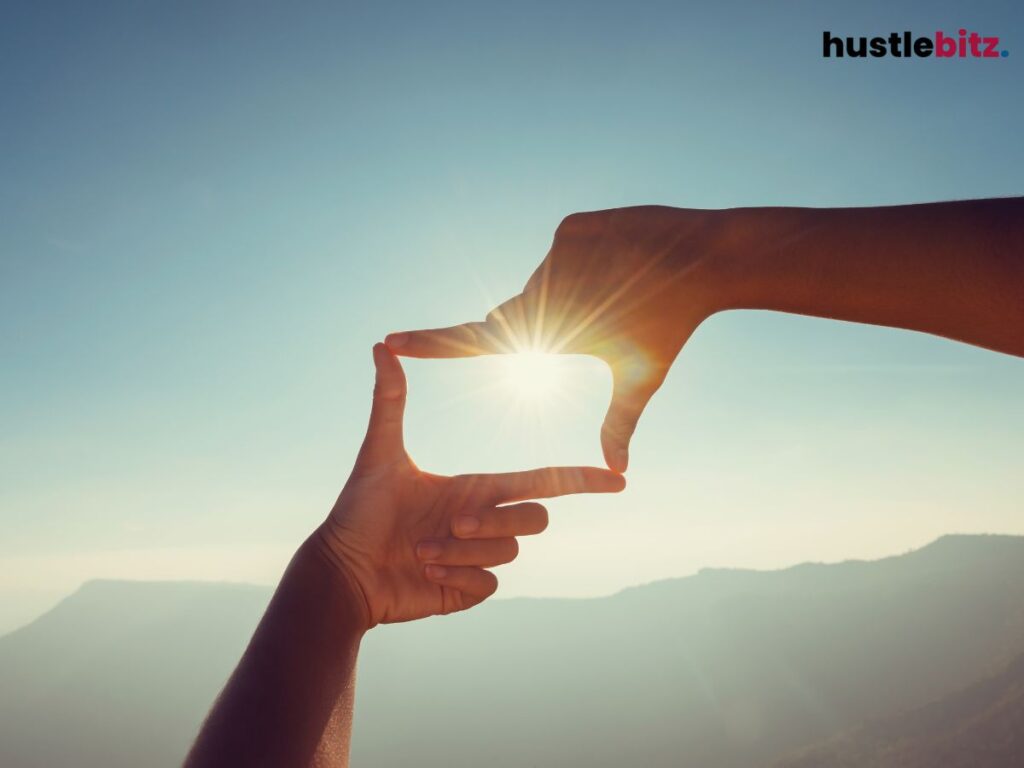 A hand making a rectangular shape focusing to the sun.