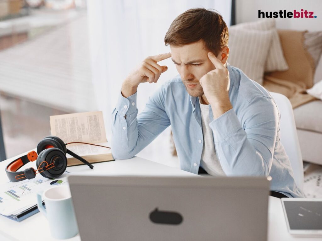 A man pointing his head with his fingers showing a focused face.