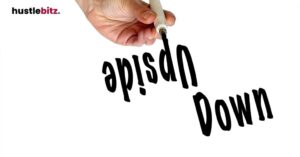 A hand writing "Upside Down" on a clear board.